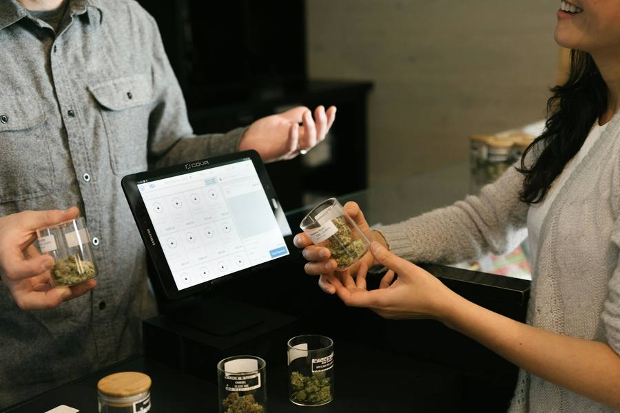 Budtender and customer at a dispensary point-of-sale tablet