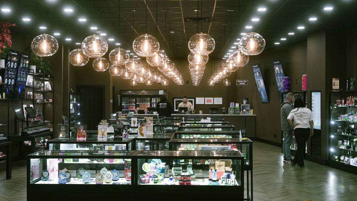 Inside a dispensary: glass display counters under rows of pendant globe lights