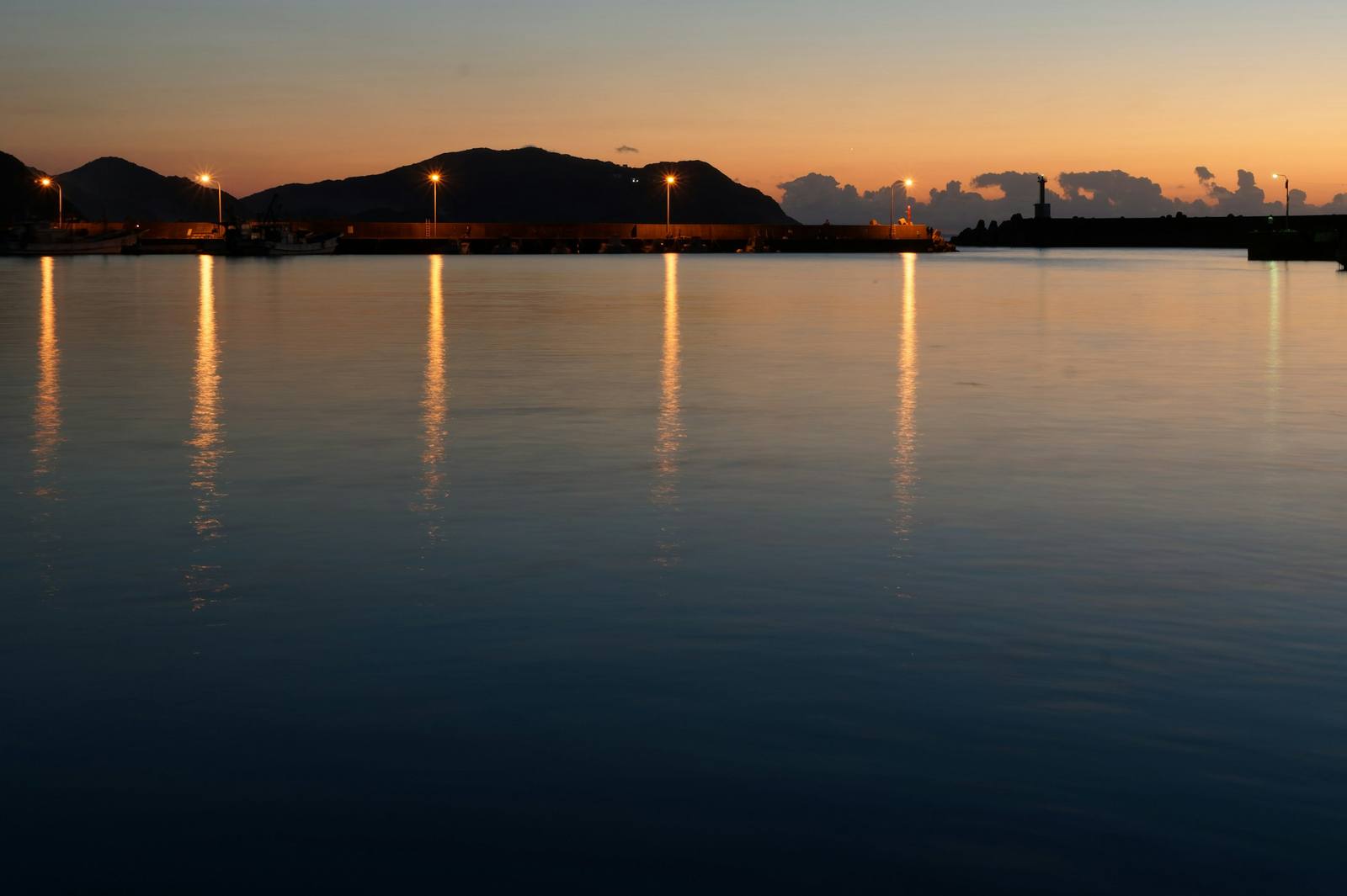 Harbor at dusk, with dock lights reflected on calm water